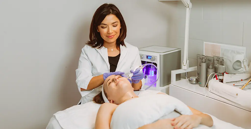 Woman receiving Diamond Glow Hydrafacial treatment at Skin by Carla Spa